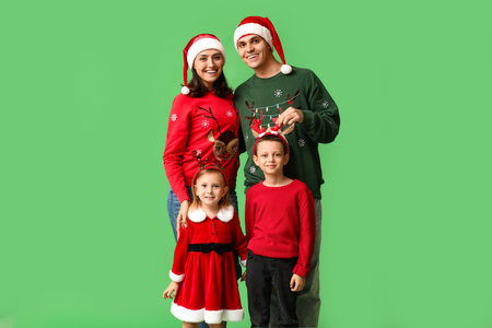 Happy family in Christmas clothes on green backgroundの写真素材