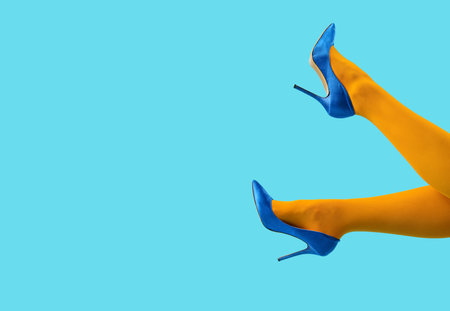 Female legs in stylish high heels on color background, closeupの写真素材