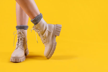 Female legs in stylish leather shoes on color background, closeupの写真素材
