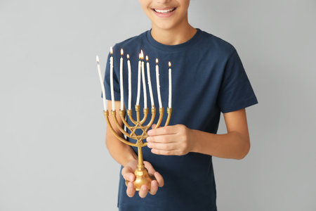 Little Israeli boy with menorah on gray backgroundの写真素材