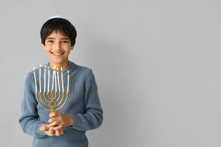 Little Israeli boy in kipa with menorah on gray backgroundの写真素材