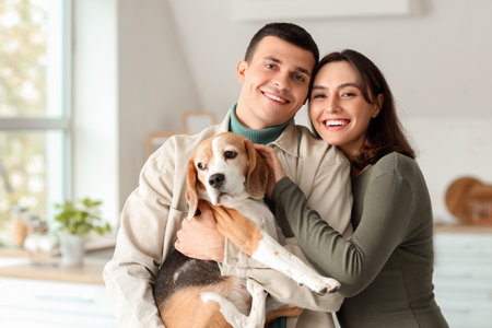Young couple with cute Beagle dog at homeの写真素材