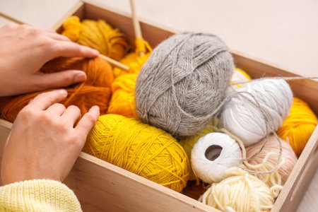 Young woman with knitting yarn at home, closeup