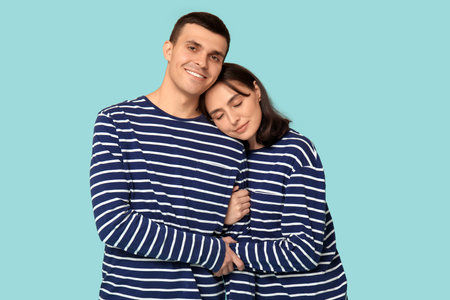 Cheerful young couple hugging on blue backgroundの写真素材