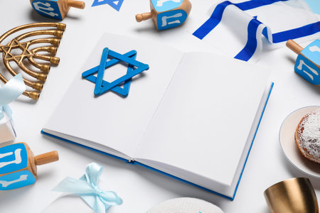 Festive composition with open book, David star and Hanukkah symbols on white background