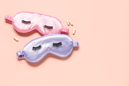 Composition with sleep masks, false eyelashes and pills on pink backgroundの写真素材