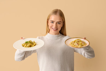 Young woman with tasty pasta on beige backgroundの写真素材