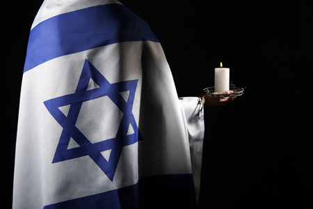 Jewish woman with flag of Israel, burning candle and barbed wire on dark background, closeup. International Holocaust Remembrance Dayの写真素材