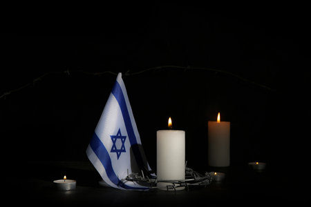 Burning candles with barbed wire and flag of Israel on dark background. International Holocaust Remembrance Dayの写真素材