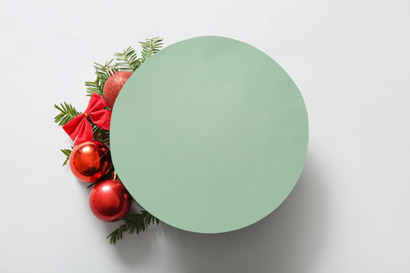 Green round blank card with red Christmas decor on white backgroundの写真素材