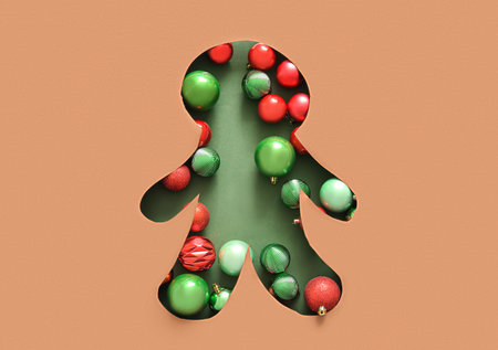 Cut brown paper in the shape of gingerbread cookies with Christmas balls on green background