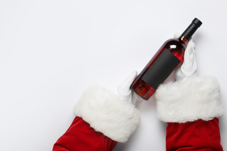 Santa Claus hands with bottle of wine on white background, closeupの写真素材