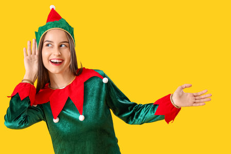 Beautiful young woman in elf's costume on yellow backgroundの写真素材