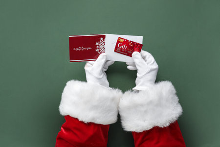 Santa hands with gift card on green background, closeupの写真素材