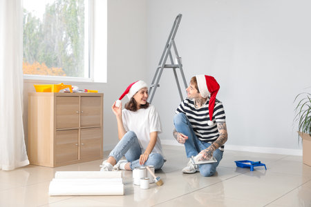 Young couple with Santa hats during repair in their new houseの写真素材