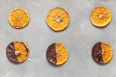 Chocolate dipped dried orange slices on gray backgroundの写真素材