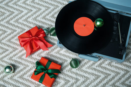 Vintage record player, Christmas gifts and balls on light rugの写真素材