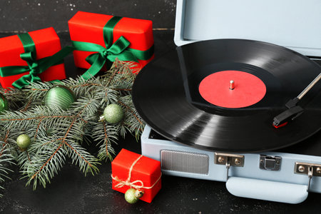 Vintage turntable with Christmas decorations and gifts on dark backgroundの写真素材