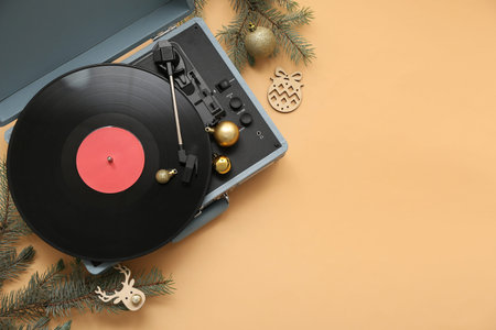 Vintage vinyl record player with Christmas decorations on beige background