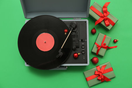 Vintage record player and gifts on green backgroundの写真素材