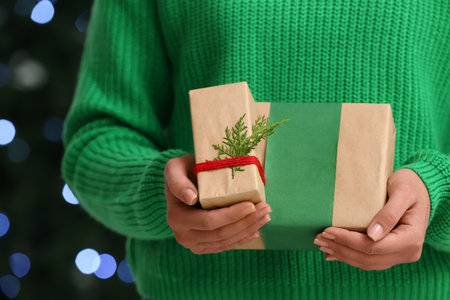 Woman holding gift boxes in festive room with Christmas tree, closeupの写真素材