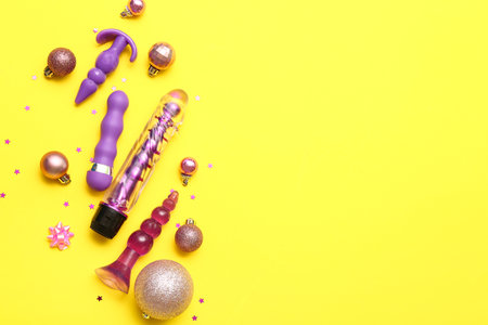 Sex toys and Christmas balls on yellow backgroundの写真素材