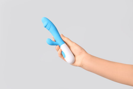 Female hand with vibrator on gray background, closeupの写真素材