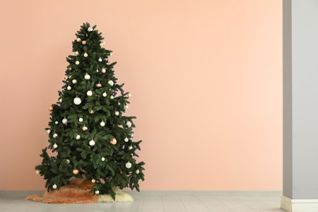 Beautiful Christmas tree near pink wallの写真素材