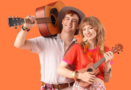Couple of hippies with guitars on orange background