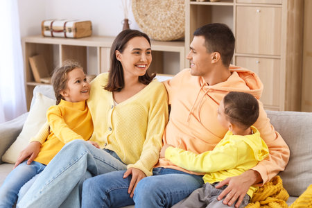 Happy family sitting on sofa at homeの写真素材