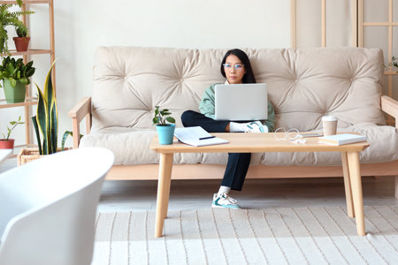 Young Asian woman working with laptop at homeの写真素材