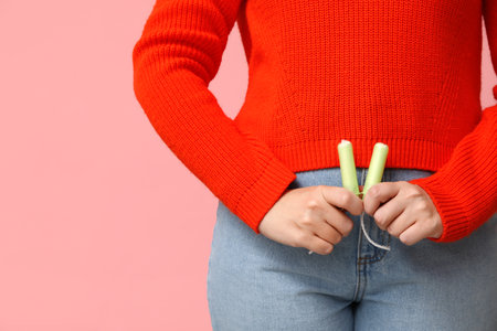 Beautiful young woman with tampons on pink background, closeupの写真素材