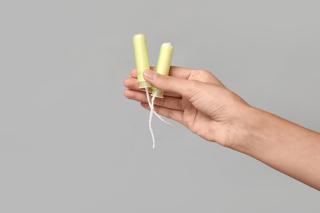 Female hand with tampons on gray backgroundの写真素材