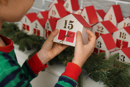 Little boy with Christmas advent calendar at home, closeupの写真素材