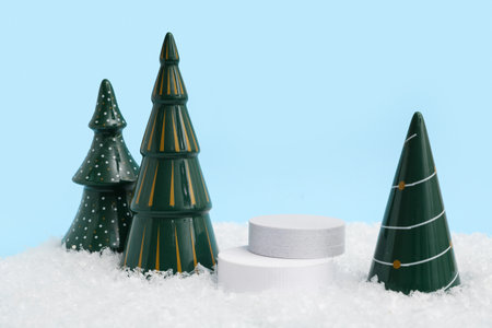 Decorative podiums with Christmas trees on snow against blue backgroundの写真素材
