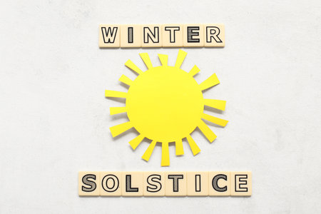 Text WINTER SOLSTICE with paper sun on white backgroundの写真素材