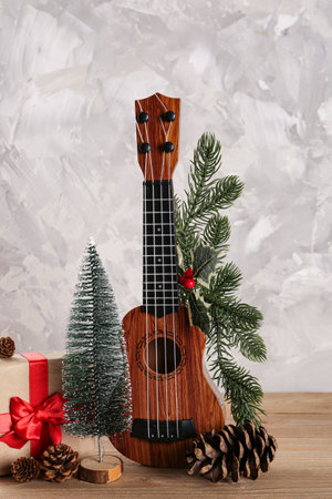 Composition with ukulele, Christmas gift and decorations on wooden table against grunge backgroundの写真素材