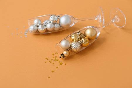 Champagne glasses with Christmas decor on orange backgroundの写真素材