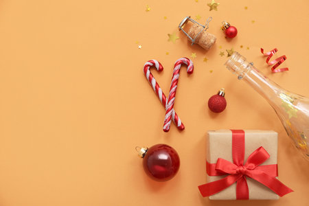 Champagne bottle with Christmas decor on orange backgroundの写真素材