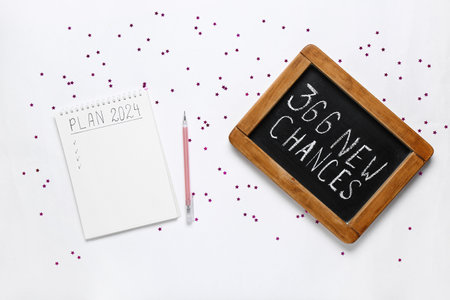 Notebook with empty to do list and chalk board with text 365 NEW CHANCES on white backgroundの写真素材