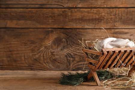 Manger with dummy of baby and hay on wooden background. Concept of Christmas storyの写真素材