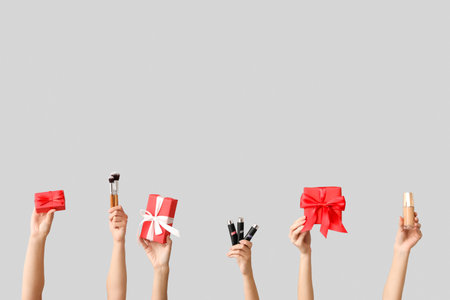 Female hands with different cosmetic products and gifts on white backgroundの写真素材