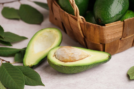 Fresh ripe avocados and leaves on white background