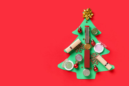 Christmas tree made of makeup cosmetics and decor on red backgroundの写真素材
