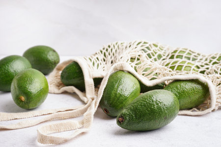 String bag with fresh ripe avocados on white backgroundの写真素材