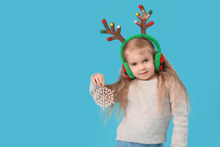 Cute little girl with deer horns on blue backgroundの写真素材