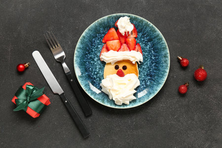 Plate with pancake in the shape of Santa on black table. Christmas celebrationの写真素材