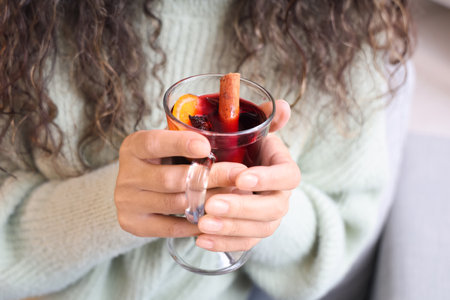 Young African-American woman with glass cup of hot mulled wine, closeupの写真素材