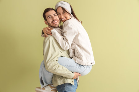 Loving couple in winter clothes on green background