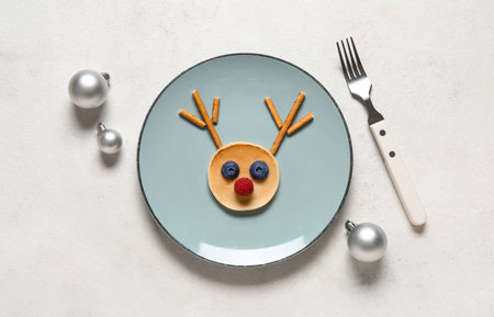 Plate with pancake in shape of reindeer on white background. Christmas celebrationの写真素材